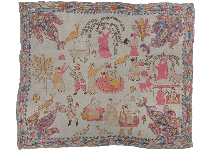 Antique Bengali figural Kantha featuring a story over multiple scenes. It may display a classic folk story or something relevant to the maker. A variety of scenes of village life are showcased; including animals being fed from trees, lovers dancing, and a man with two faces. A sense of symmetry is achieved by the inclusion of a grand paisley motif in each of the four corners.