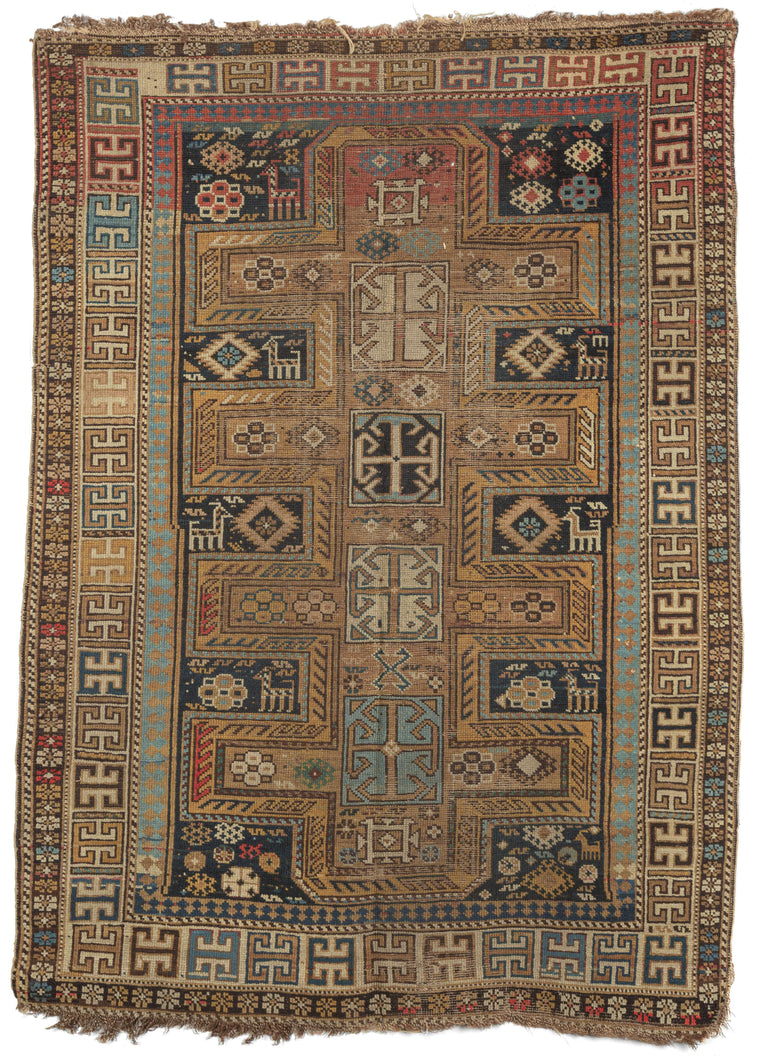 Antique Caucasian Kazak scatter rug featuring a camel colored cross motif on a dark indigo ground. Small animals, protective symbols and geometric designs fill in the space between crosses. The color palette is predominantly gold and camel, light and dark blues with smatterings of red here and there. 
