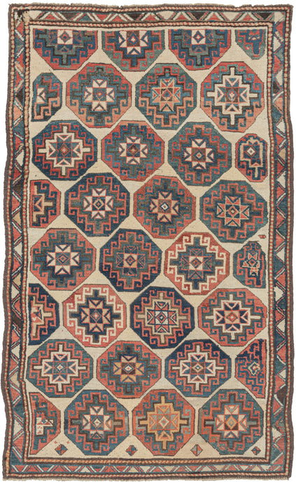 Antique Caucasian Kazak rug featuring offset Memling guls in primary colors of red, blue, and yellow on a soothing ivory ground and framed by an interlocking sawtooth border. Some guls become distorted as these reach the edges. Gentle abrash, wonderful spacing, a pleasing palette, and just enough wonkiness make this a very satisfying piece. 