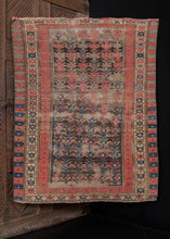 Antique Caucasian Kuba rug, handwoven during the first quarter of the 20th century. The rug is composed of a geometric design arranged diagonally, with alternating rosette and crab borders. The color palette includes bright red, deep blue, ivory, and brown, which has oxidized. In fair condition, with signs of wear throughout, 