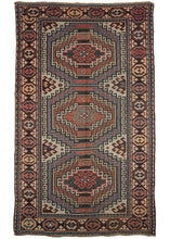 Antique Caucasian Shirvan area rug featuring three medallions each with a concentric hook motif in red, blue, yellow and dark brown on an ivory ground. The main border is composed of a large alternating scarabs in red, blue and yellow. A well composed and visually arresting example of caucasian weaving.
