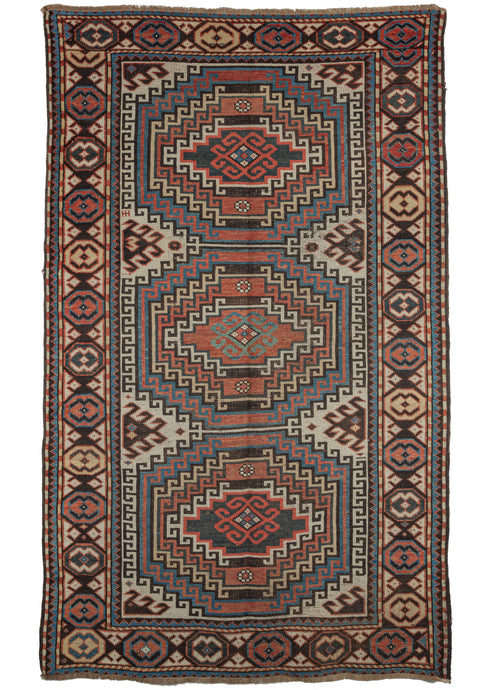 Antique Caucasian Shirvan area rug featuring three medallions each with a concentric hook motif in red, blue, yellow and dark brown on an ivory ground. The main border is composed of a large alternating scarabs in red, blue and yellow. A well composed and visually arresting example of caucasian weaving.