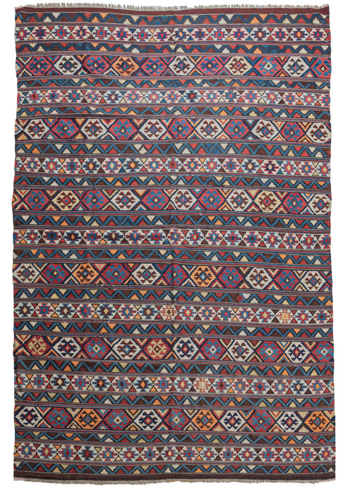 Antique Caucasian Shirvan Kilim featuring a horizontally striped design, with each stripe containing geometric shapes and symbols. The color palette contains madder reds, indigo blues, deep browns, light creams, yellows, and oranges. 