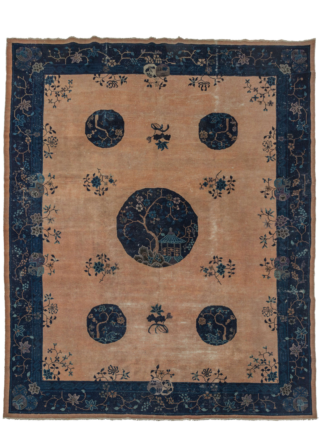 Antique Chinese FaTi area rug composed of an ivory field with a peachy tint, and medallions in all shades of blues. The central medallion features a gazebo and tree design, with the smaller medallions featuring a similar design. The border is composed of a floral meander on a dark blue ground. The blossoms in the design are a mix of peach blossoms, chrysanthemums, and peonies, common flowers used in Chinese imagery. The color palette is limited to myriad shades of indigo blue, and soft peachy ivories.