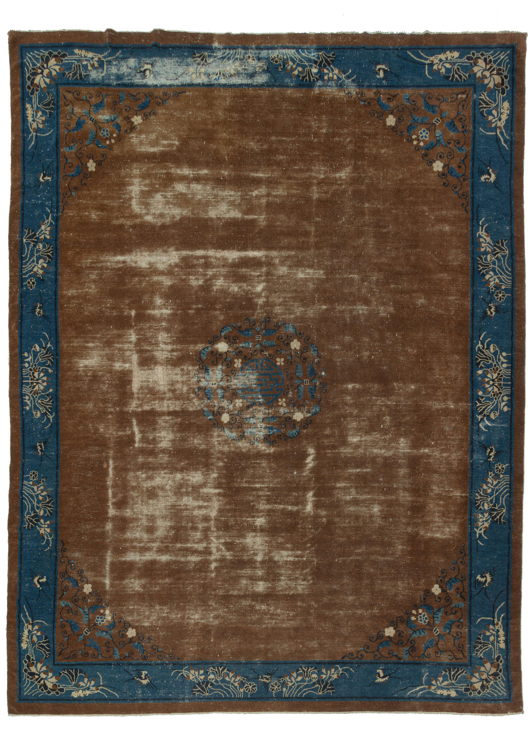 Antique Chinese Peking rug featuring an expansive chocolate ground worn in many areas to the white cotton foundation. A central medallion is composed of a coin motif surrounded by scrolling vines in black, blue, and white. The same scrolled vines can be seen in each cornice of the otherwise unadorned field. A lively blue main border showcasing flying birds and blooming flowers that almost appear to sway with the wind. 
