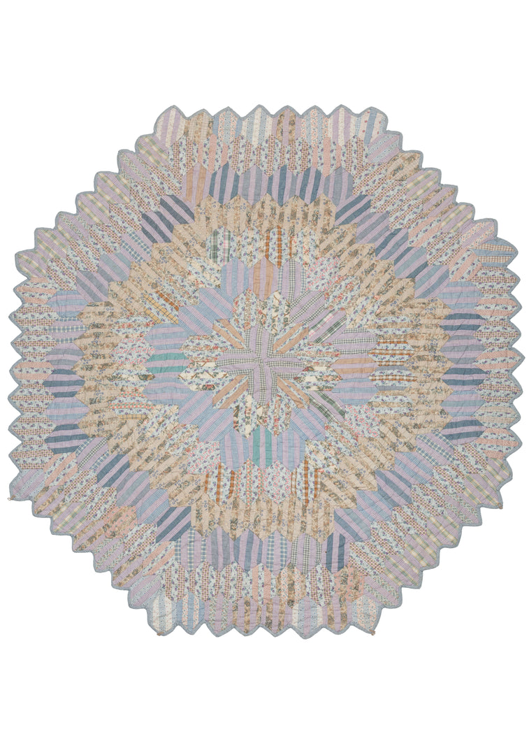 Antique N American quilt based on a rectangular hexagonal quilt block (pattern) that starts in the center and expands out. It is composed of pieced together fabrics, most probably recycled materials from around the home. The scalloped edge of the quilt suggests this piece was sewn by an expert quilter. 