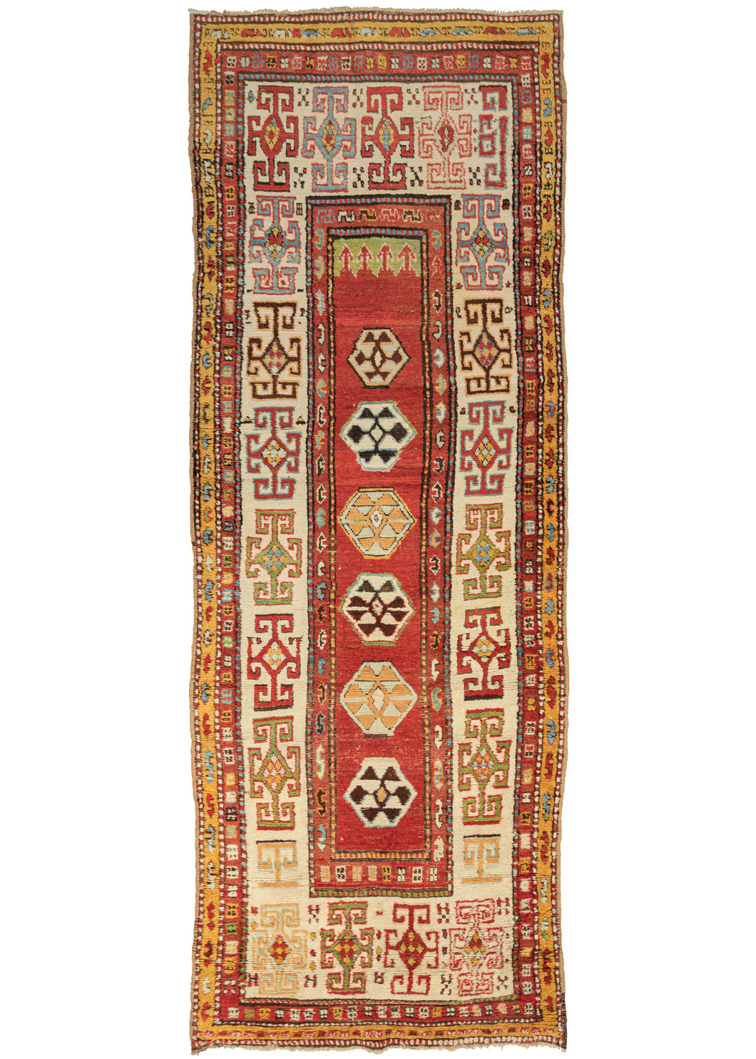 This Kazak Runner features a thin field of polygons on a red ground with arrows near a small green section at the top giving the pattern subtle directionality. The polygons are filled with protection symbols and slightly shift in scale unintentionally. It is framed by a very wide and relatively bright ivory main border with large-scale geometric devices in red, yellow, green, and icy blue.