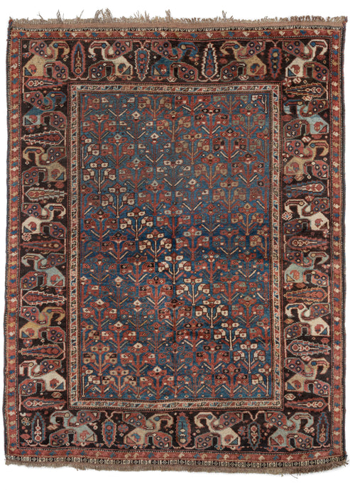 Antique Persian Khamseh Rug featuring a deep color palette of intense blues and reds, the whole lifted up by yellow, and ivory accents throughout the design. The diagonal allover pattern of flowering shrubs is contained by a large main border of mother and daughter boteh alternating with cypress tress.