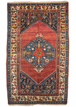 Antique NW Persian Hamadan scatter rug featurinng a pulsating red field between an indigo central medallion and cornices and contains three distinct borders in red, ivory, and blue. The reds on this rug have been “painted” over using fountain pens and ink, a practice common during the 1920s and often associated with Sarouk rugs of the period.