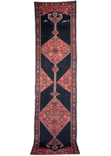 Anntique NW Persian Kurdish runner featuring composed of two red grounded lozenges filled with a variation on the classic Herati pattern. This is contrasted by the simple yet very deep navy field. There is a date (1306) and the word "Senneh" rendered in farsi to one side of the rug. The years 1306 would translate to 1888 in the Gregorian calendar. 