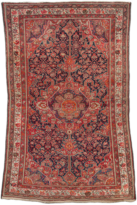 Antique NW Persian Malayer Area Rug featuring an ornate central medallion and cornices on herati patterned field. The design is primarily rendered in blues, red, ivory and brown but a variety of accents in soft yellow, purple, green and an impactful orange add nice depth. Three prominent borders are composed of distintive floral meanders, from geometric to naturalistic.