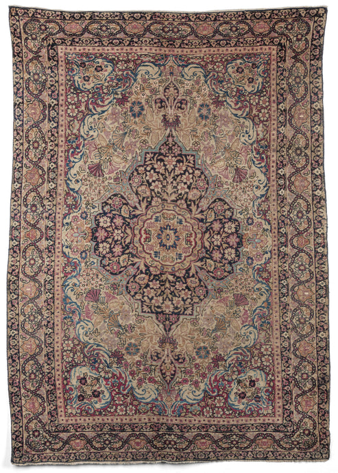19th century Persian Lavar Kerman area rug composed of an elaborate curvilinear floral design, with a central medallion. Scalloped cornices frame the central design. The main border continues with the elaborate floral theme, with single blossoms around a trellis. The minor borders are variations on the flower vine design. The color palette is composed of stunning blues, pinks and reds with soft camels and creams.