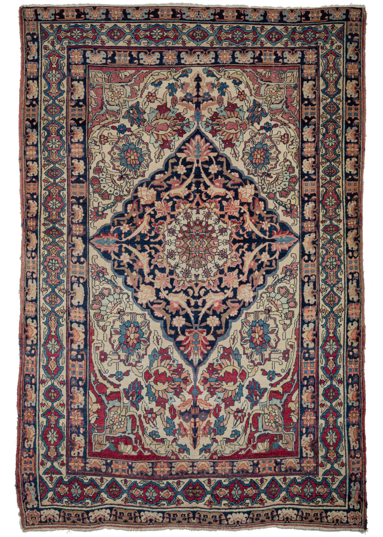 19th Century Lavar Kerman features a central medallion with a curvilinear floral design and scalloped cornices. The field is a rich raspberry color, nicely contrasted by the lighter pinks and creams of the cornices. The minor borders are composed of vine and leaf motifs, while the main border contains alternating blossoms in diamonds and cartouches. 