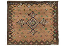 Antique Persian sofreh kilim featuring a central medallion composed of one large diamond and four smaller diamonds atop a camel field. A chocolate border zig-zags around the camel and both sections are filled with geometric diamond-shaped rosettes in different combinations of green, red, and ivory.  