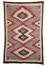 Antique Navajo scatter rug Featuring a repeating sunburst pattern in browns, reds, and ivory. A simple brown border frames the simple and elegant jagged diamond motif.