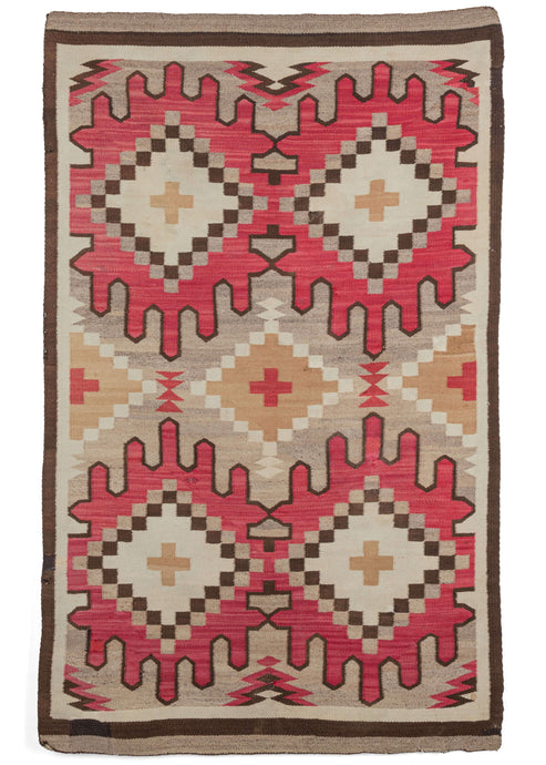 Antique Navajo scatter rug featuring a symmetrical design composed of softly colored diamonds atop an eye-catching red splatter that is outlined in black wool. The field is soft undyed grey wool, while the light browns and ivories offer a contrast to the design. 