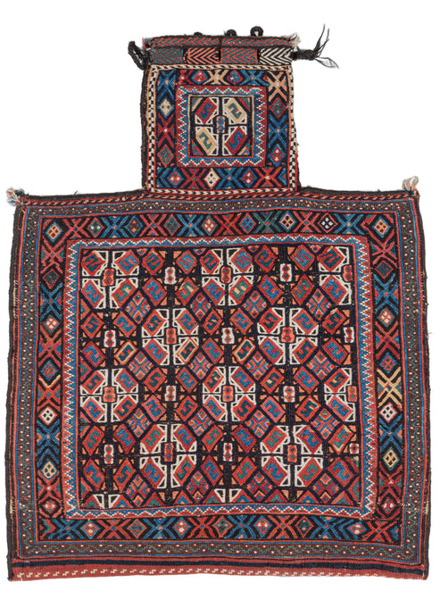 Antique Afshar salt bag featuring a soumak woven face with a satisfying repeat field pattern of small diamonds and diagonal striped orbs composed of smaller geometric shapes. The pattern is simple yet complex with bright, blues reds and oranges playing off the strong contrast of black and white.  It is framed by a border of alternating X's and diamonds reminiscent of the classical egg and dart motif. The neck has a single orb with it's own personal 
