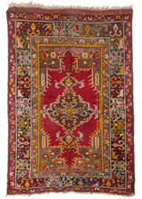 Antique Turkish Maden Scatter rug with  saturated golden and red tonnes atop a grey undyed field 