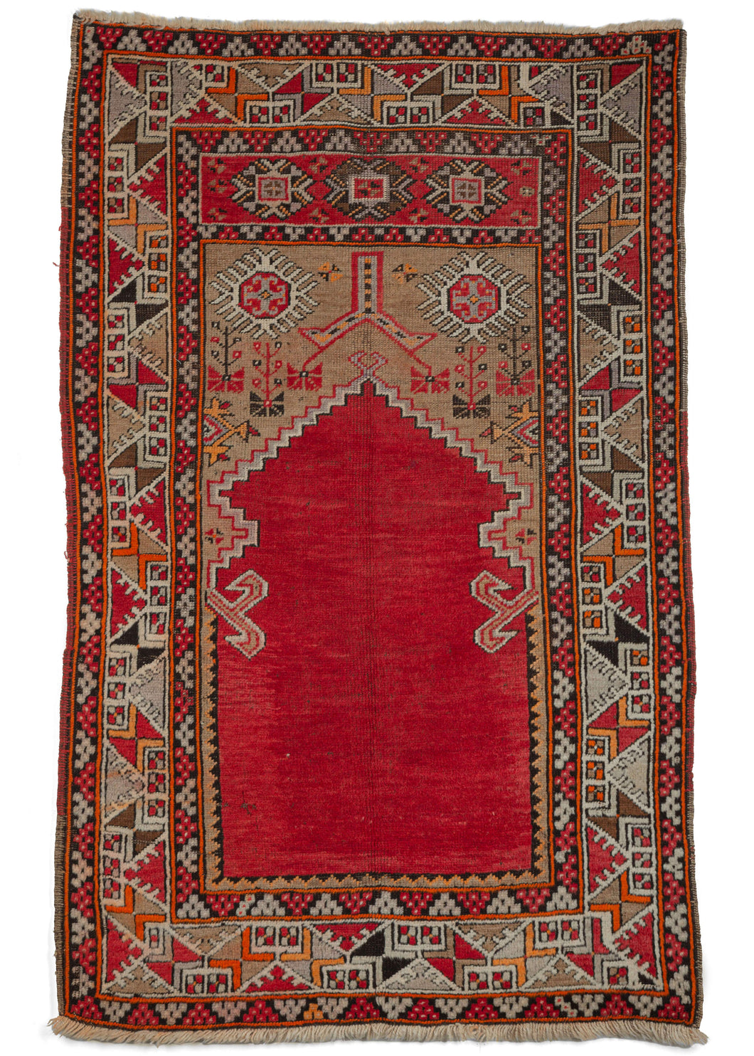 Antique Turkish Karaman prayer rug featuring a bright red mihrab (prayer niche) on a camel ground. The largely geometric details are rendered in brown, purple, orange, yellow, and black, with the tricolor selvedge bringing it all together.