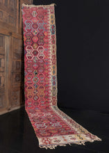 Reyhanli rug fragment handwoven during the mid 1800s in Turkey.  It features an abstract geometric pattern on a lush purple field, while the designs are woven in blues, yellows, and ivories with brown details. The border features more geometric designs on an ivory field. The original braided kilim ends are still intact. In good condition for its considerable age, flatwoven with a light handle. 