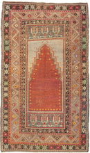 Antique Turkish prayer rug featuring the classic long and narrow latch-hooked Mihrab associated with the town of Nigde between Yahyali and Konya in central Anatolia. The main field is composed of the rich orangey-red mihrab on a silvery ground of faded fuchsine dyes and flanked by two cartouches each with rows of three stylized blossoms. With a main border featuring a soft zigzag meandering around olive-like cintamani symbols on a caramel ground.