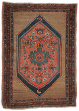 Antique West Persiann Serab area rug featuring a loosely drawn coral lozenge inset on another navy lozenge atop a plain camel field. The lozenges feature blue/green jewel tones and pops of orange with a central rosette surrounded by fish like boteh. Three dainty borders frame this simple yet elegant composition.