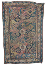 Antique Caucasian soumak area kilim featuring a variety of intersecting shapes in faded blues, greens, corals, yellow and ivory. The haphazard shapes appear to be an attempt at the famous “dragon” design” which went awry. Three ivory palmettes really pop in the field drawing the eye and brightening the rug. The main border features a pinwheel of four serrated leaves alternating with rosette filled diamonds.