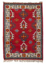 Vintage Indian rug with a bright red background and funky geometric and floral design. In excellent condition, signs of wear consistent with age. 