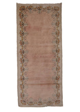 Chinese Khotan rug, handwoven during the 1980s in NW China. It features a plain soft pink field with a scalloped border. In very good condition, signs of wear consistent with age.