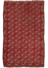 Northern Afghani Turkmen area rug featuring a bold geometric design known as Kizil Ayak. The color palette is made up of bright reds and oranges with black, undyed natural grays and white providing detail and contrast. The whole is framed by a single border.