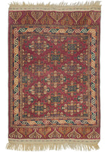 This Midcentury Yomud Turkmen Rug features an allover "Kepse" gul design in navy, green, orange, and ivory on an aubergine ground. The field is framed by a dynamic meandering "S" scroll main border that jolts the viewer like flashing lights. The main border is drawn in thick ivory cursive against big blocks of green, orange, and aubergine.