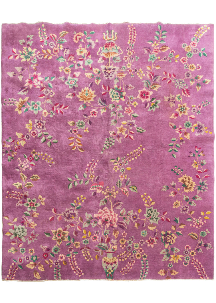 Chinese purple pink deco featurinng truly unique light purple field. The design is open and borderless, and is composed of large-scale floral motifs like sprays, vines, and tendrils growing from vases at either ends of the rug. Notice the stippling and color variation, beautifully rendered by the weaver. The accenting palette is composed of greens, pinks, and golden yellows. 
