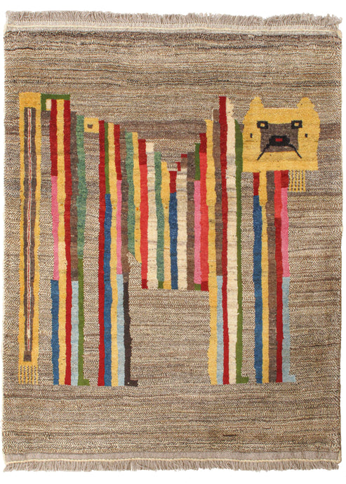 This Rainbow Lion Gabbeh features a stylized lion form on an undyed gray wool backdrop. It is composed of various polychrome vertical stripes and a squared yellow head to create a fun and fantastic abstraction of the classic lion motif. The pile is densely woven, making this a plush rug.