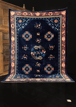 Foo-dog rug handwoven during middle of 20th century in China. Central medallion featuring two foo-dogs. Four lotus medallions and various floating floral sprays atop the deep blue indigo field. 
