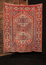 Afshar rug handwoven in South Iran during the second quarter of the 20th century. Two blossoming diamond medallions rendered in ivory, blue and brown with touches of orange and yellow on a coral field. Flowering vine composes the meandering minor border. 