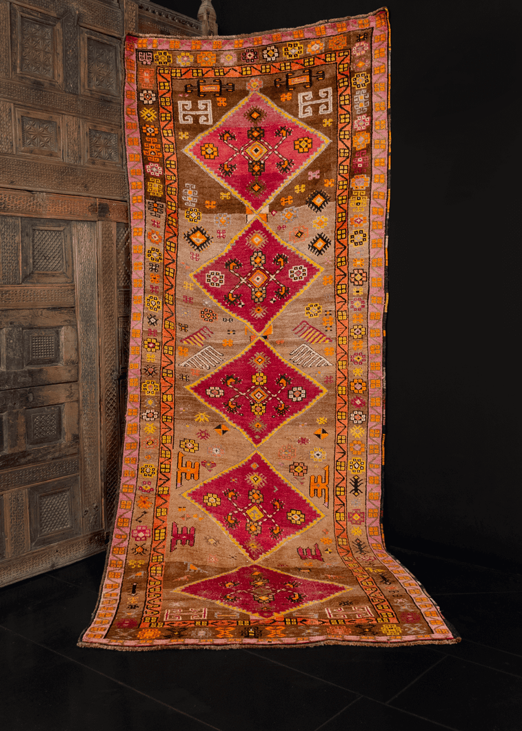 Kars runner from Eastern Anatolia handwoven during third quarter of 20th century. Five raspberry central medallions on a camel ground. Bright oranges and yellows provide contrasting details. 