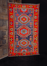 Derbent rug handwoven in the Daghestan region of Southern Russia during middle of 20th century. Bold geometric design in bright reds, purples and blues. Three central medallions with two half medallions. 