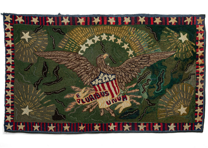 Depression Era N American hooked rug featuring a stars and stripes border and an eagle carrying a red, white and blue shield with a banner reading 'E Pluribus Unum' on a green field. Recently professionally restored, this piece is in excellent condition.