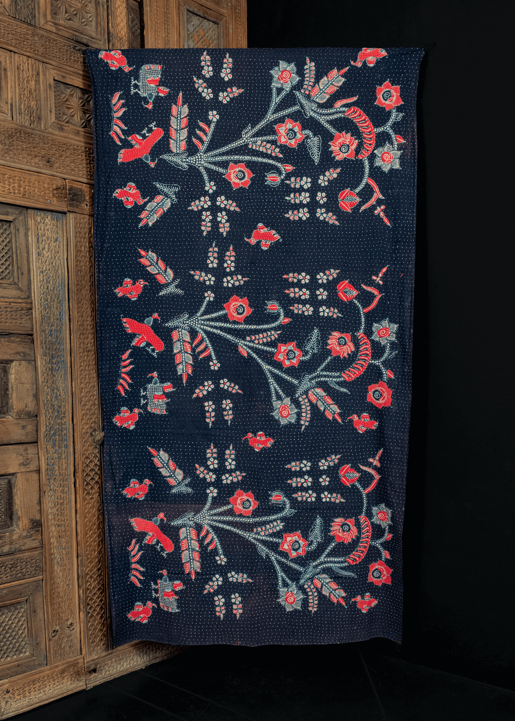 vintage skirtcloth from Java, Indonesia blockprinted with  a bouquet of flowers in red, white and blue on a dark blue ground with white polka dots. in very good condition, with some sun fading along old fold lines. 