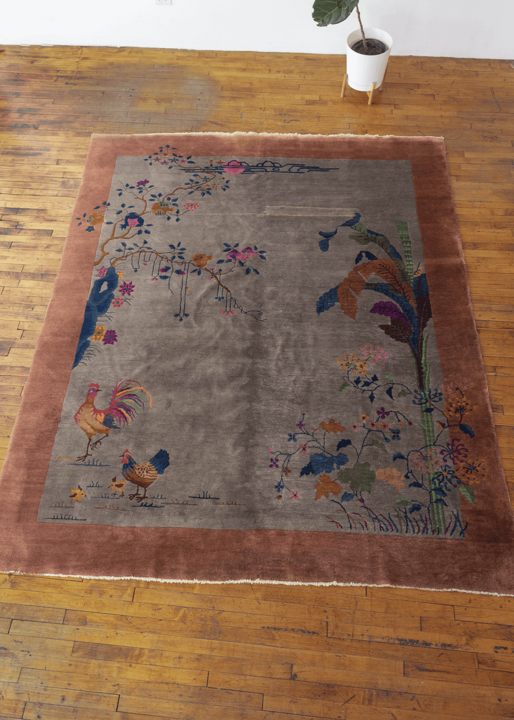 Chinese Deco rug with salmon border and silvery gray field with rooster motif on the lower left corner, banana tree and floral motifs on the right corner and more floral motif throughout. In excellent condition, with no signs fo wear 