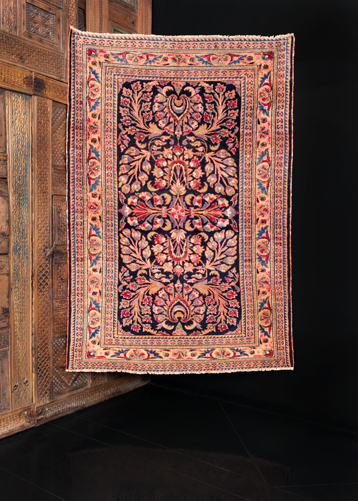 Mehraban rug handwoven during second quarter of 20th century in Western Iran. Detailed floral spray in pink, purple, blue and red atop a black ground. 