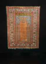 Silk Kayseri handwoven during middle of 20th century in Central Turkey. The Mihrab, or prayer niche, features a velvety orange field with two ivory columns and a hanging lantern. Pink, aqua, chartreuse and siren red. 