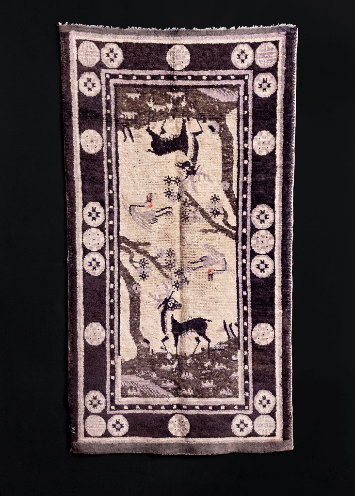 Pictoral Mongolian rug handwoven early 20th century. Mirrored design of a stag under a tree with a crane flying above. Black, gradations of grey and faded purple. 