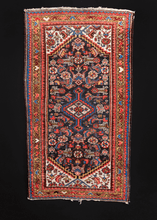 Hamadan rug handwoven during second quarter of 20th century in Western Iran. Classic geometric design in red and blue with pops of yellow and ivory details. Herati pattered field surrounded by colorful border of alternating hearts. 