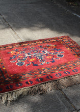 Vintage Turkmen wall hanging with unilateral fringe. Bold red ground, deep blues and soft browns and yellows. Central medallion of stylized flowers. 