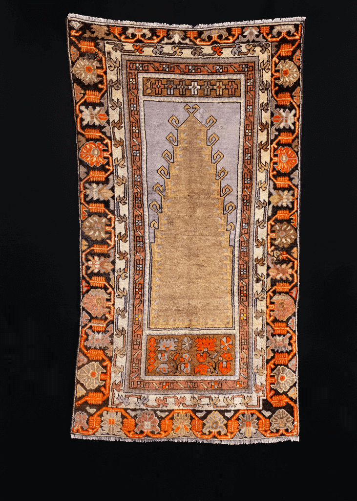 Prayer rug handwoven during second quarter of 20th century in Central Anatolia. Latch hooked mihrab woven with soft golden wool on a faded purple silver field. 