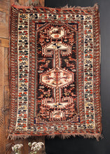 Lori rug handwoven in Southwest Iran during second quarter of 20th century. Deep browns, ivory and warm red with touches of yellow and green. Graphic central design complemented by stylized animals and protection symbols. 
