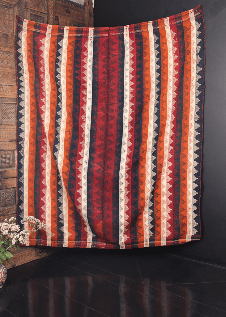 Early mid century multipurpose kilim woven in two pieces seamed at the center. Vibrating stripes with alternating triangles in white, orange, red and blue. 