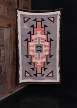 Navajo rug handwoven in Southwest US during second quarter of 20th century. Simple geometric design in pink, white and brown on heather grey field. Colorful repairs in green, blue and red. 