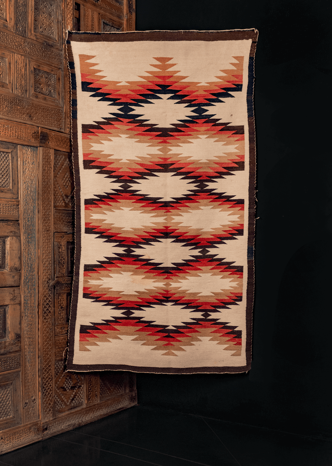 Navajo Flatwoven rug with a small-scale sunburst pattern in brown, pink, cream, ivory, earth tones.